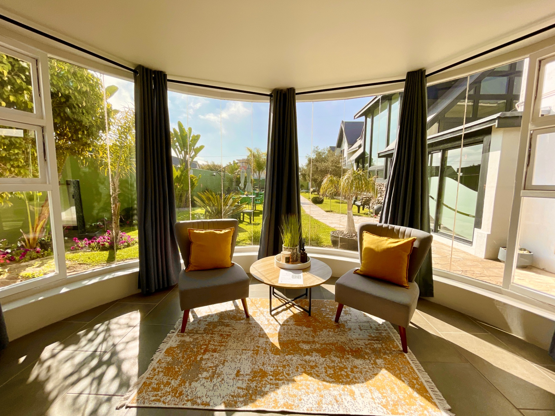 Curved bay window with sitting chairs and garden